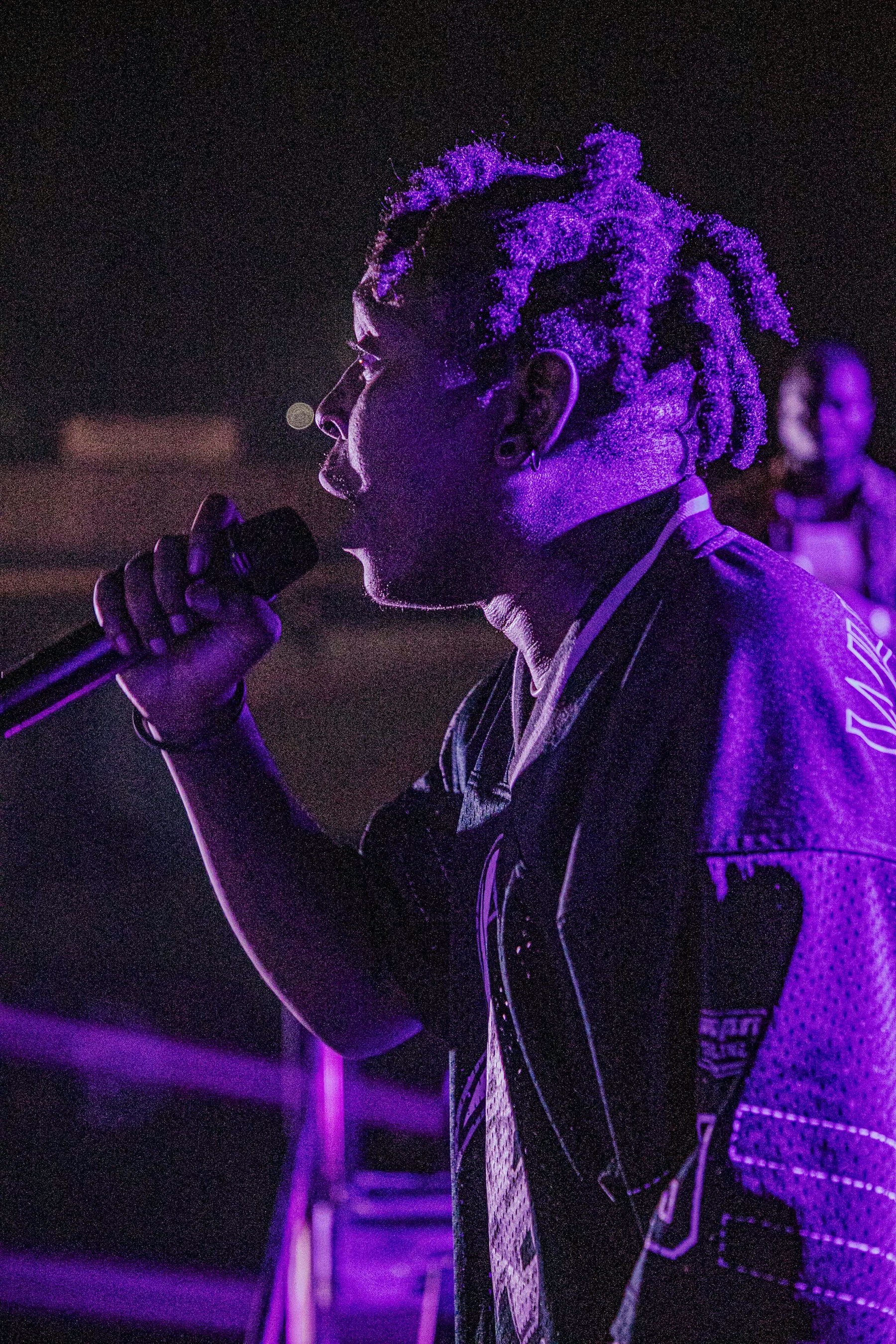 Artist performing under purple stage lights