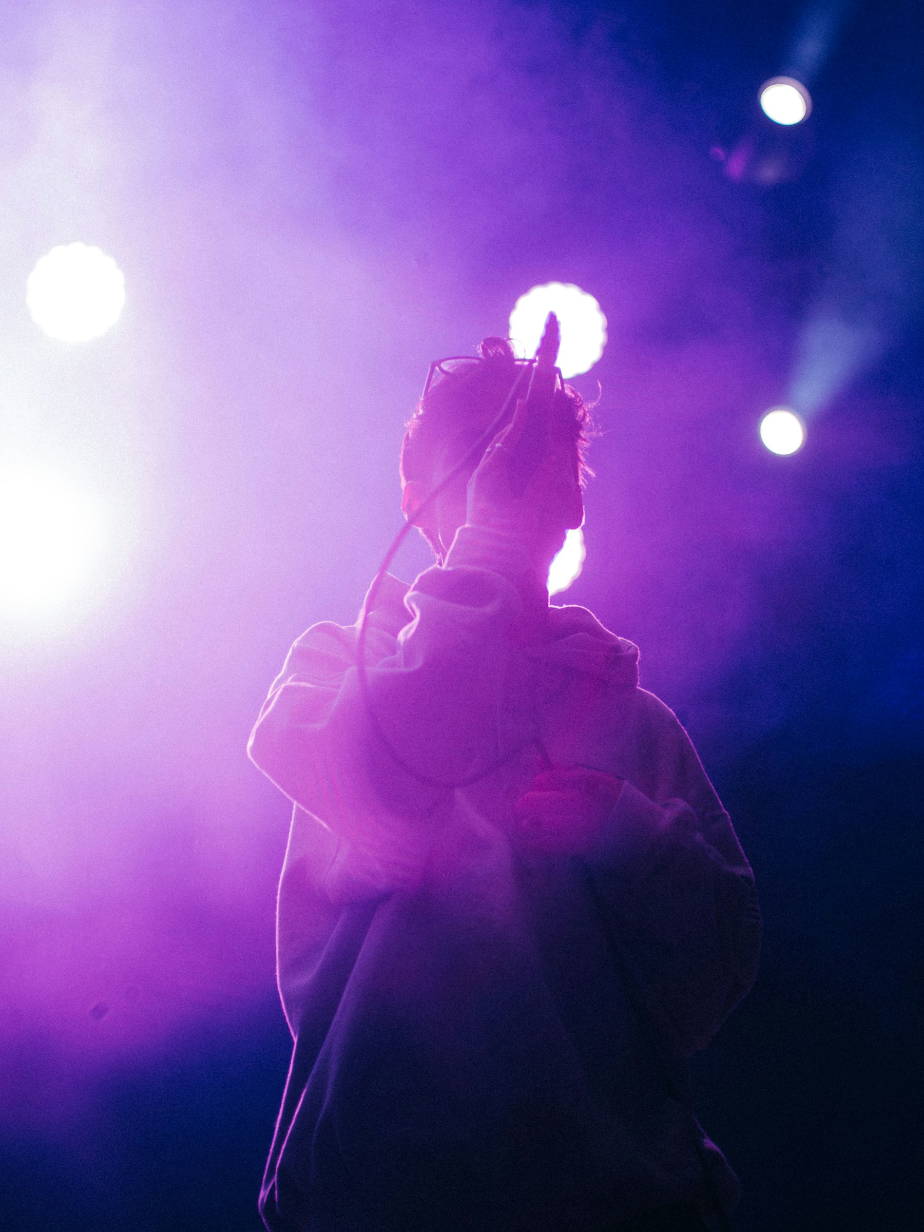 Live performer surrounded by purple stage lighting
